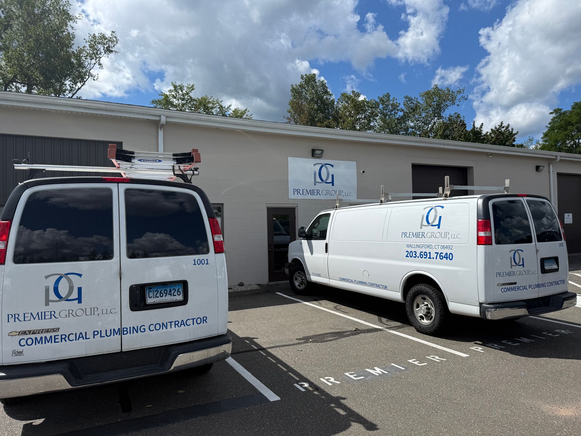 Two white vans parked outside a commercial building. The vans and building display the logo for ICG Commercial Plumbing Contractor.