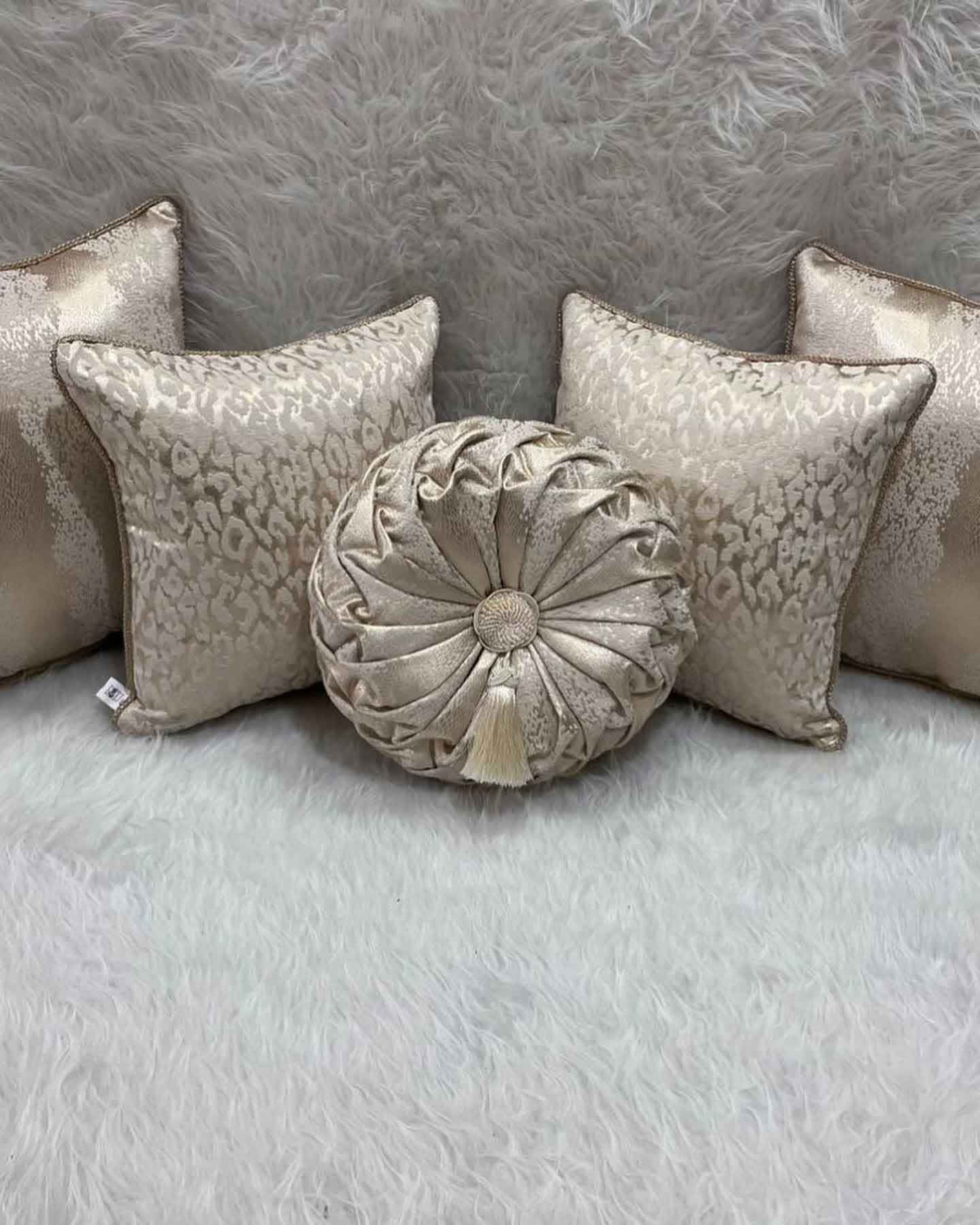 A group of pillows sitting on top of a white rug.
