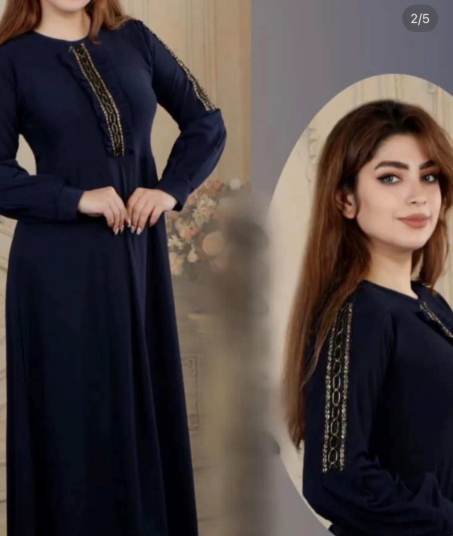 A woman in a long blue dress is standing in front of a mirror