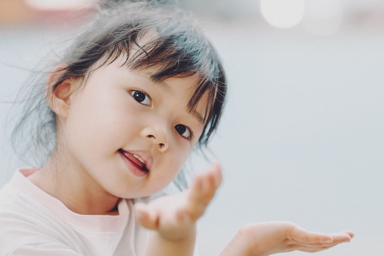 child making a request with her hands