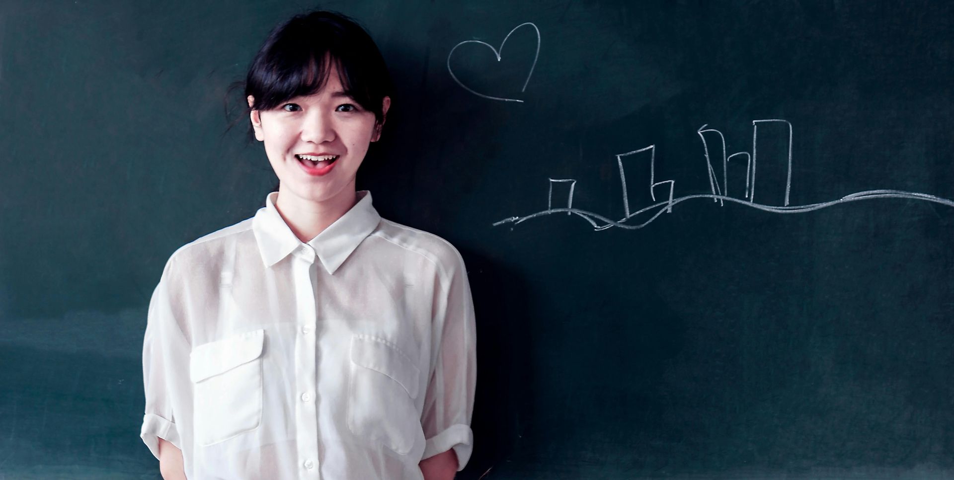 girl standing in front of a progress chart on a chalkboard
