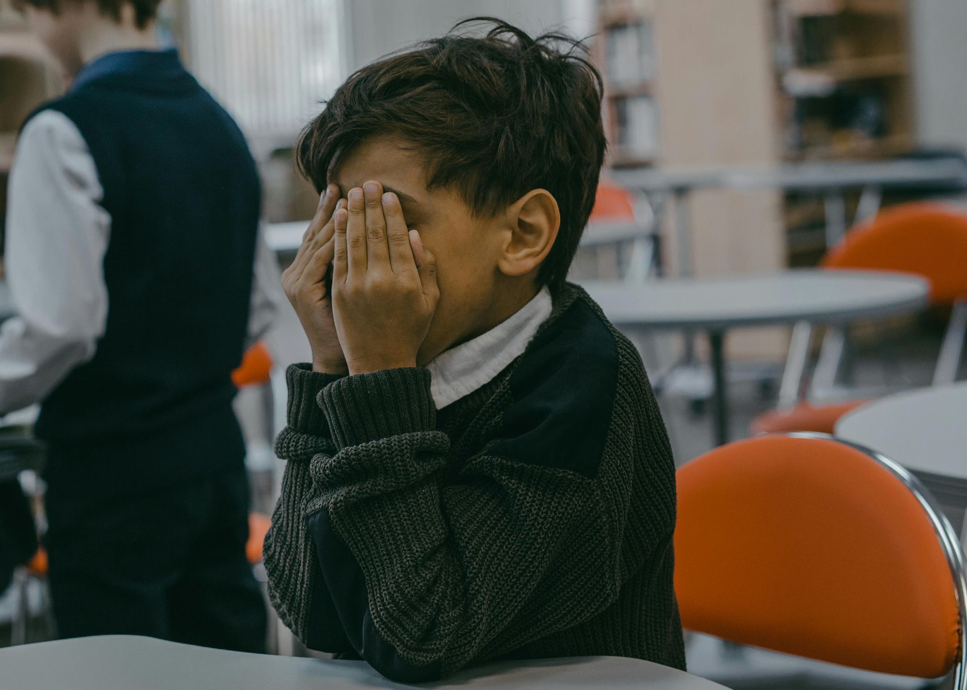 child covering face with hands