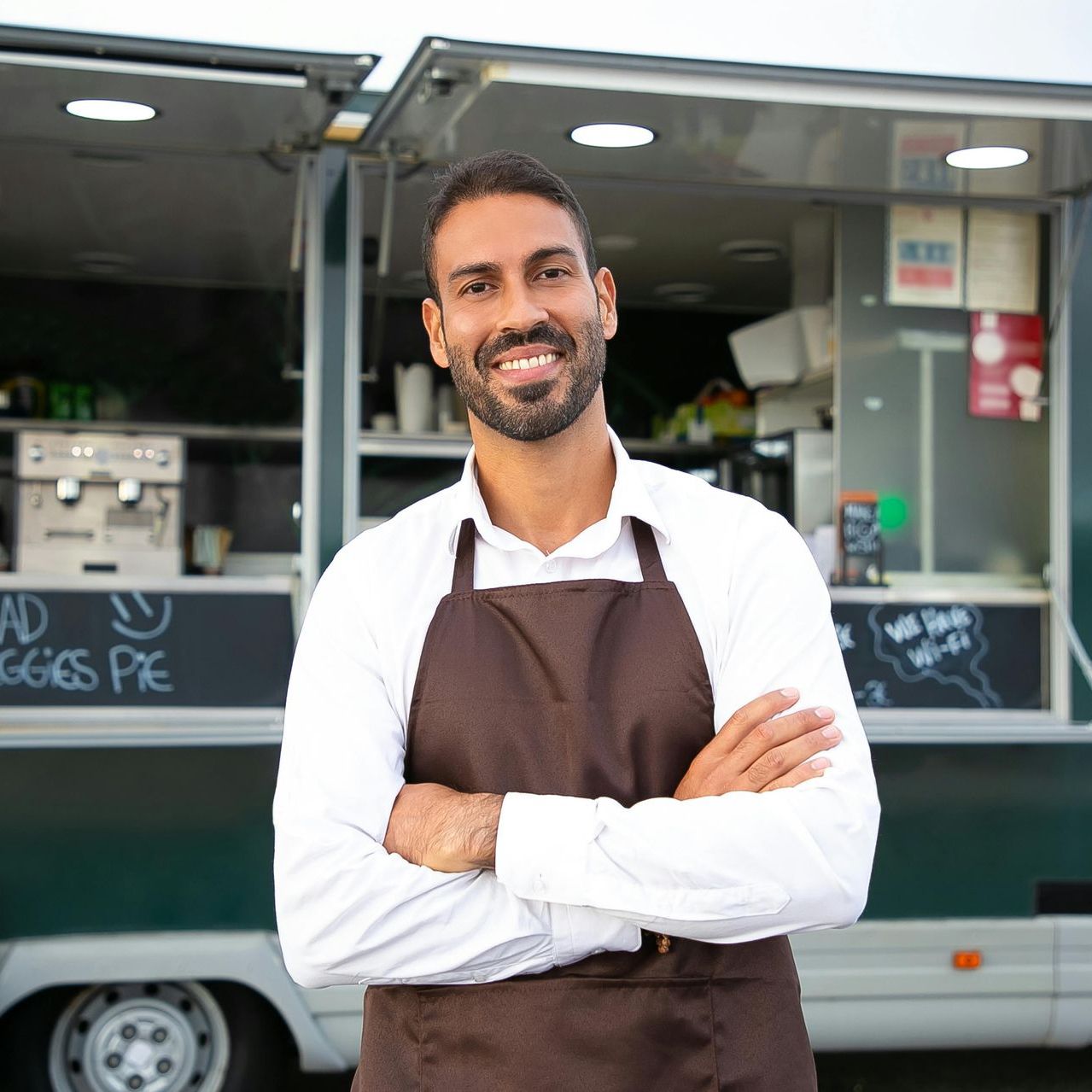 stock photo of man with an apron smiling directly in front of the camera