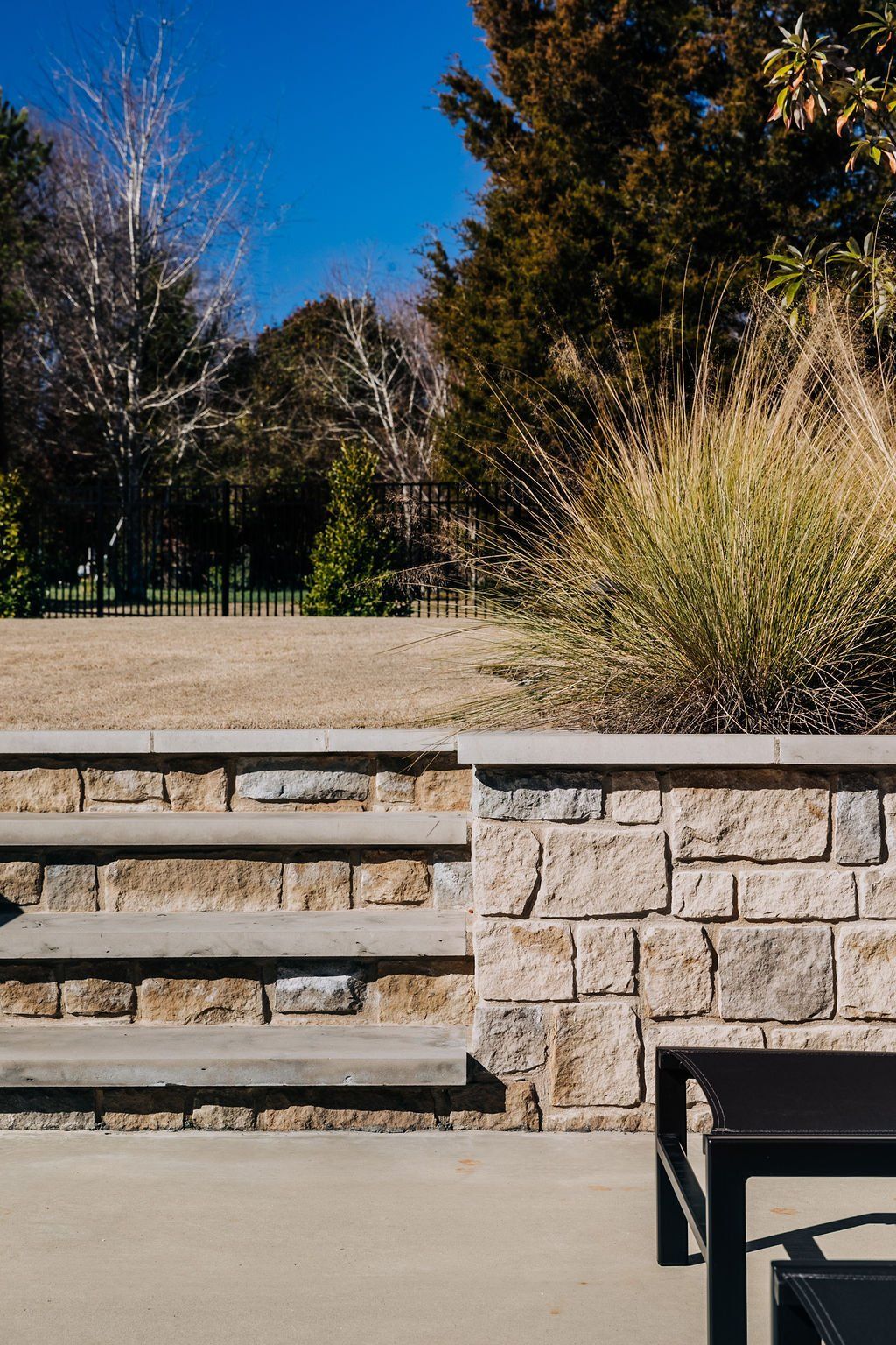 Stone retaining wall with stairs and landscaping.