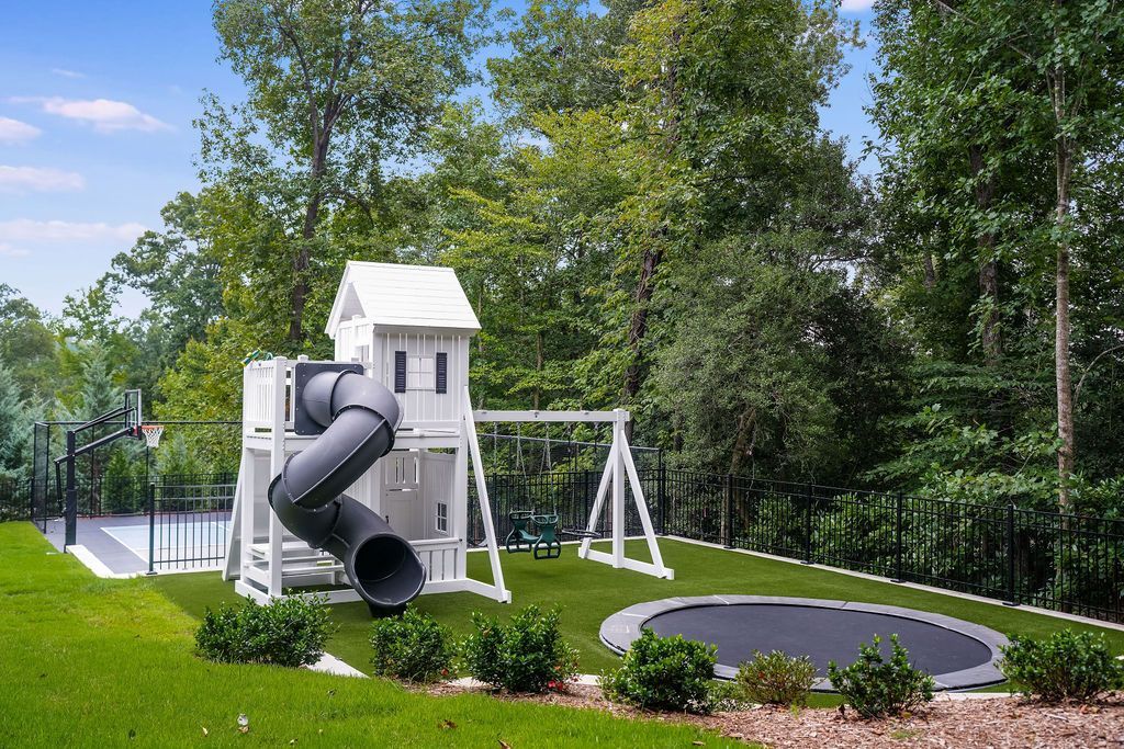 White play set with in-ground trampoline and artificial turf