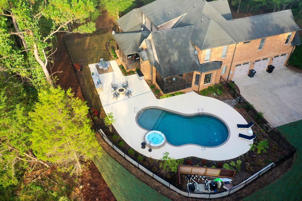 Ariel of pool, hot tub, spray deck, fire pit and outdoor kitchen.