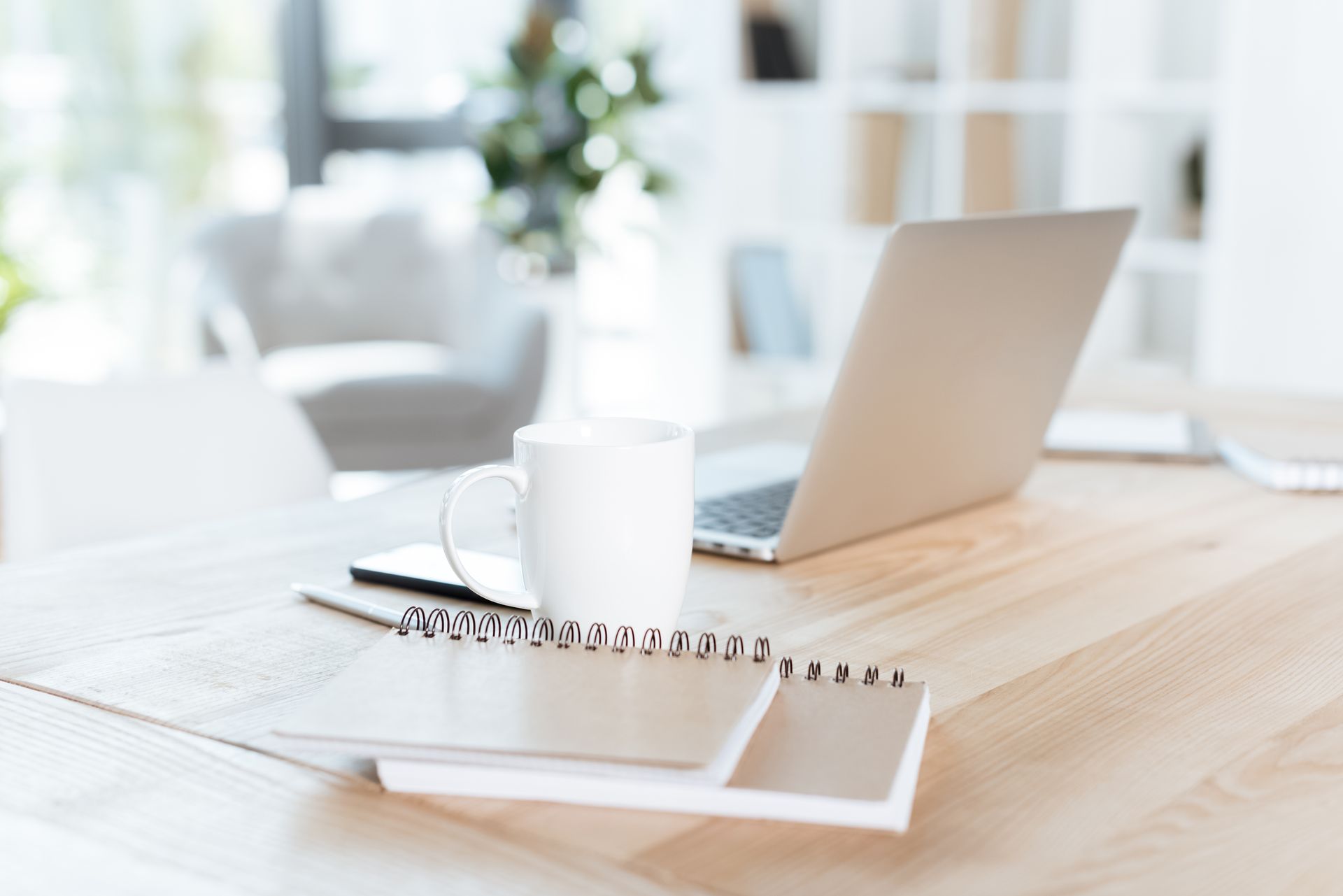 A wooden desk with a laptop and a cup of coffee on it.