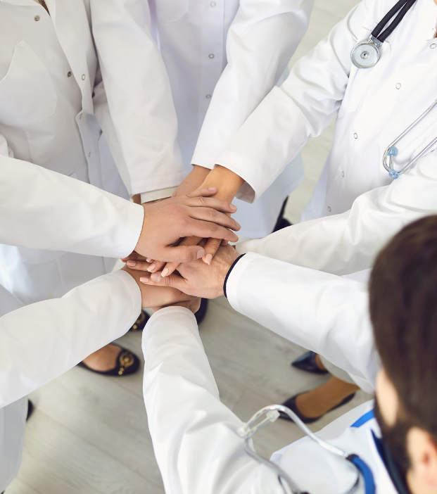 A group of doctors are putting their hands together