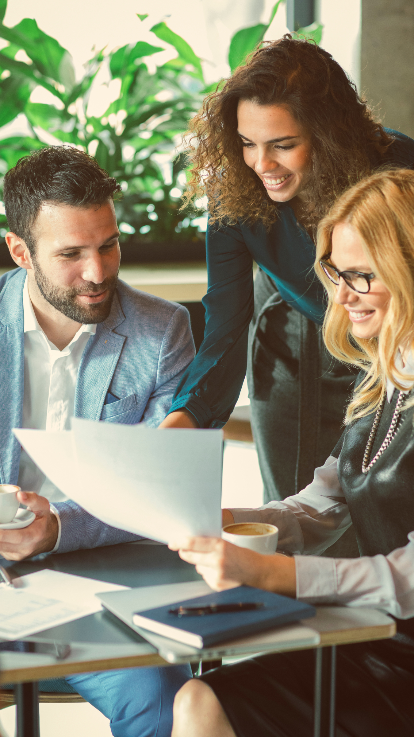 A group of people are sitting at a table looking at a piece of paper.