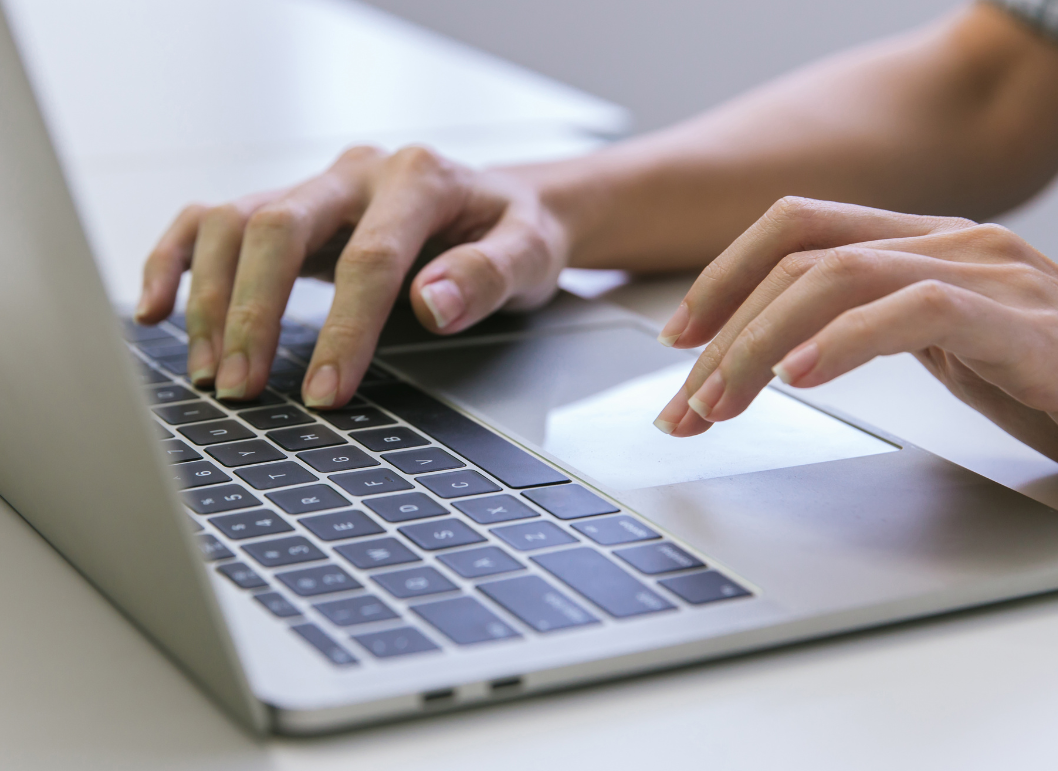 A person is typing on a laptop computer.