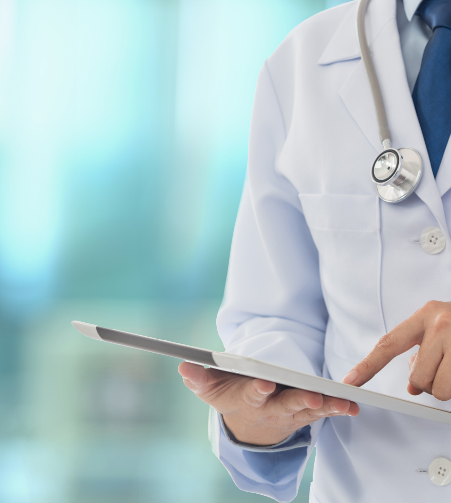 A doctor with a stethoscope around his neck is holding a tablet