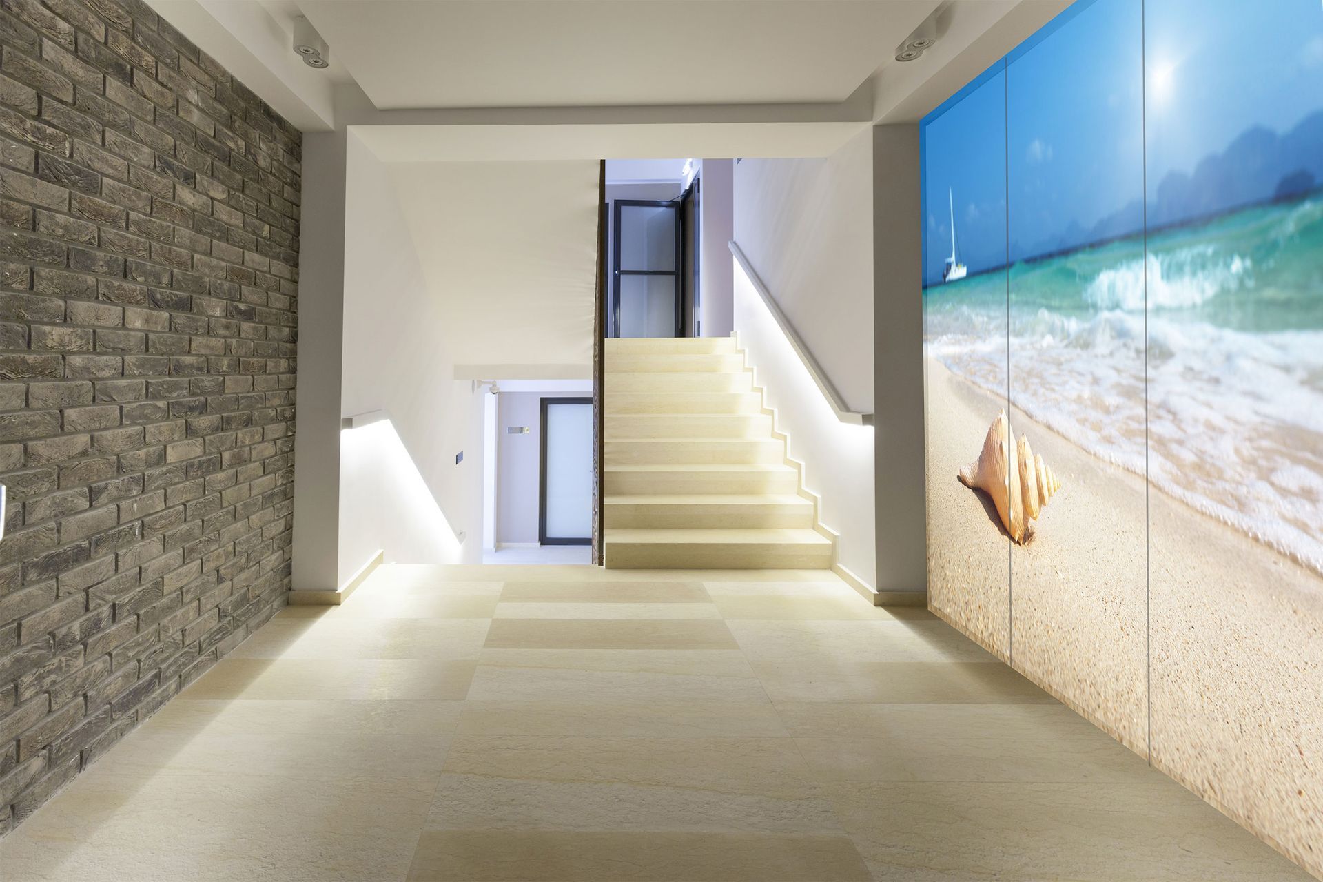 Ein Flur mit Treppe und einem Bild von einem Strand an der Wand