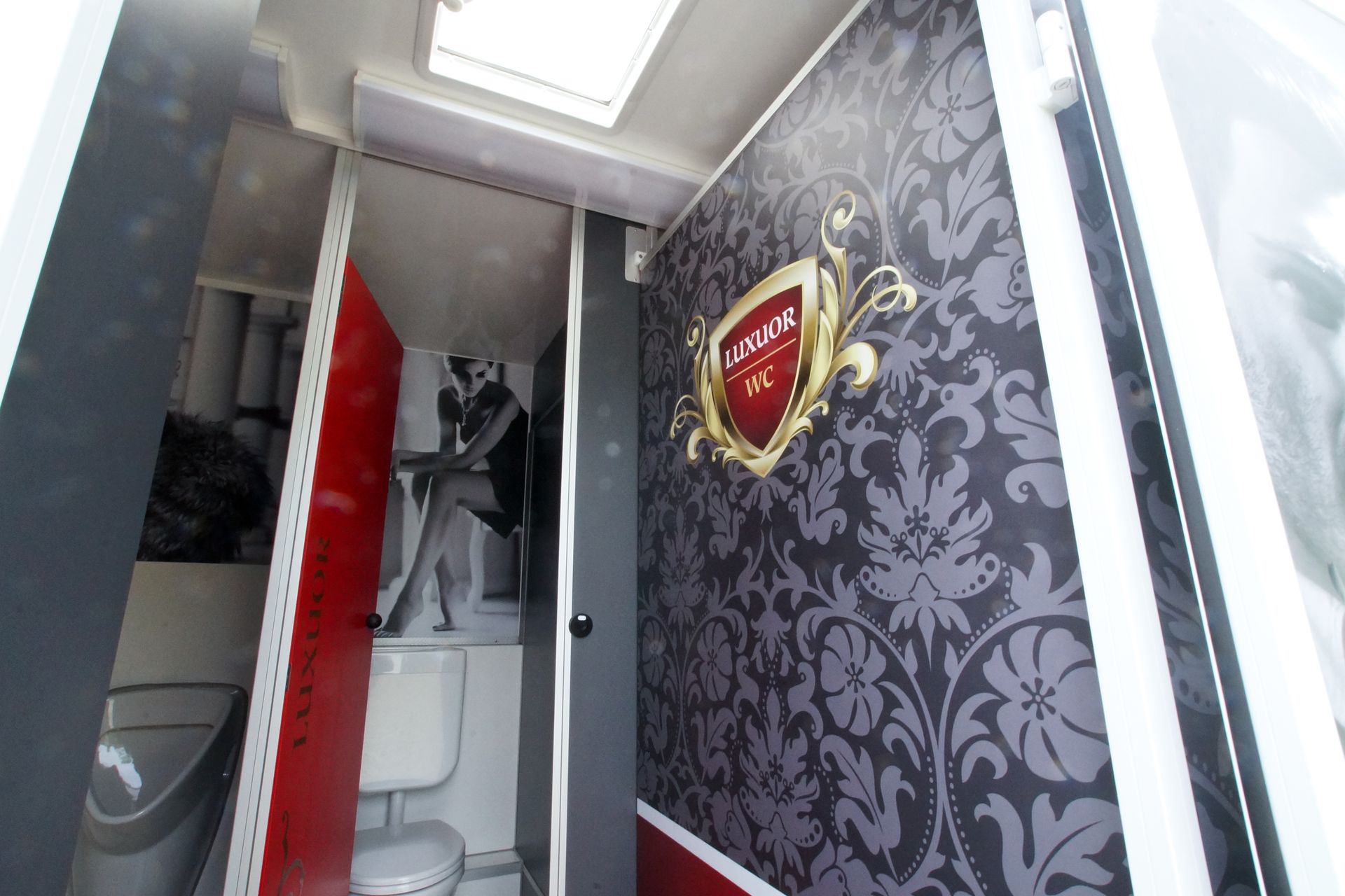 Ein Badezimmer mit Toilette und einem Schild an der Wand sowie einer Fotowand.