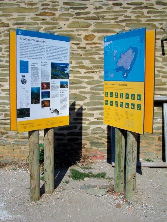 Eine Steinmauer mit ein paar Schildern darauf