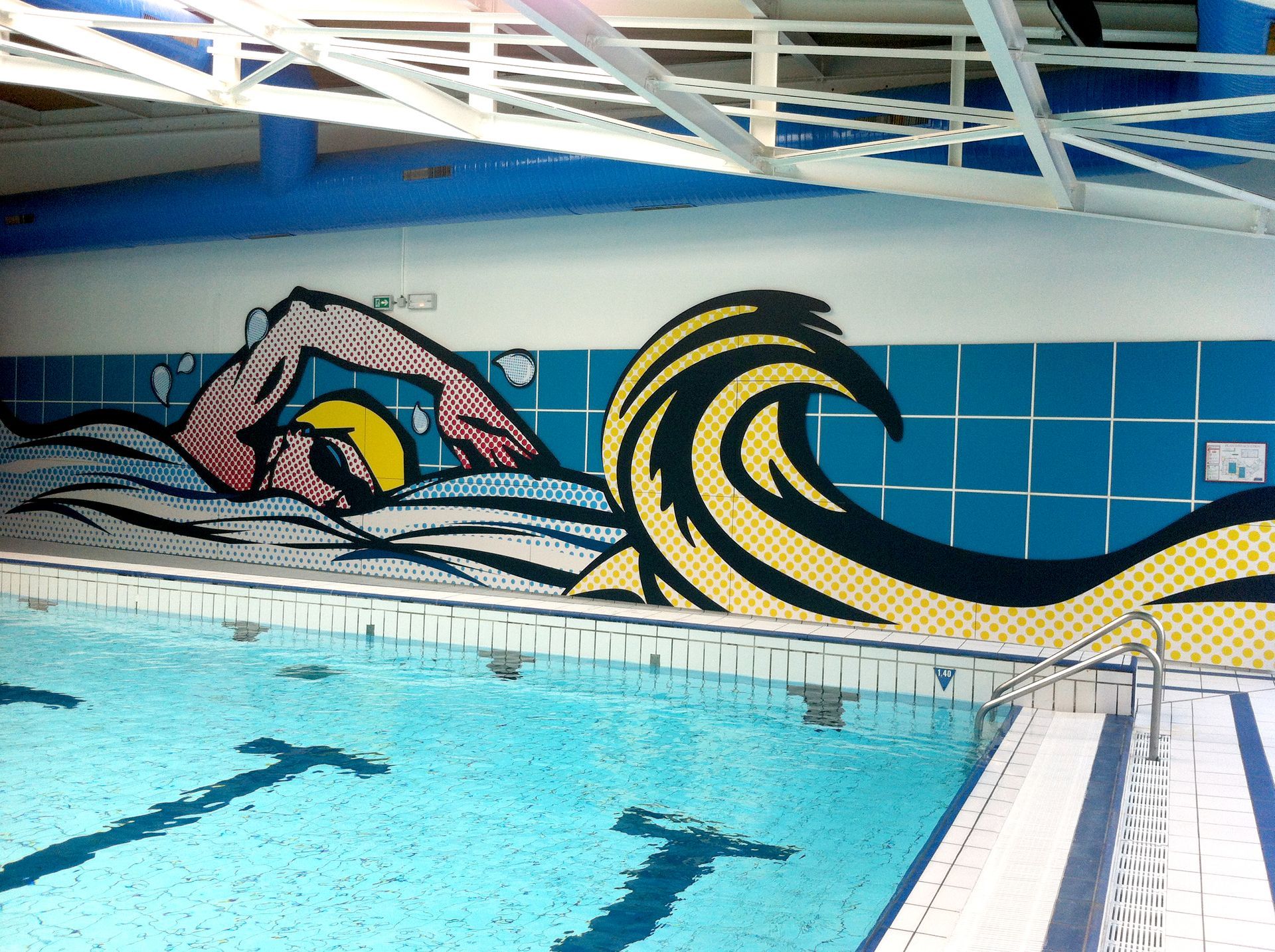 Ein Schwimmbad mit einem Wandbild einer schwimmenden Person an der Wand