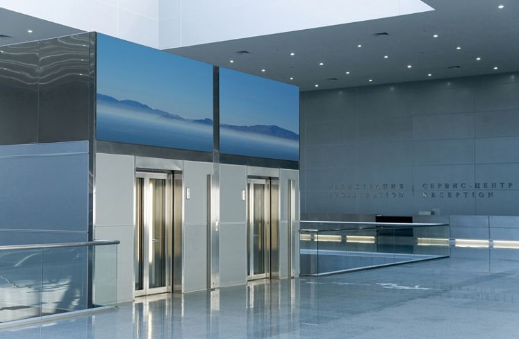 Eine Lobby mit Aufzug und einem großen Bild an der Wand