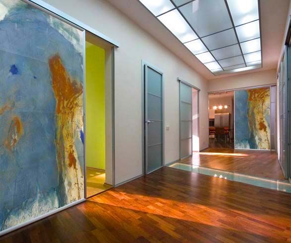 Ein Flur mit Schiebetüren und einem Gemälde auf der Tür