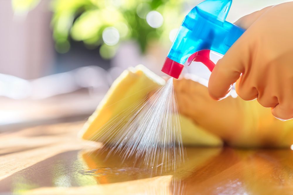 A person is spraying a sponge with a spray bottle.