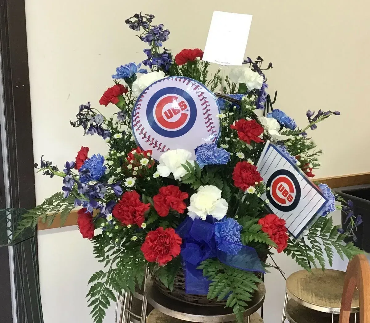Floral arrangement in blue, white, and red with a Chicago Cubs logo and flag.