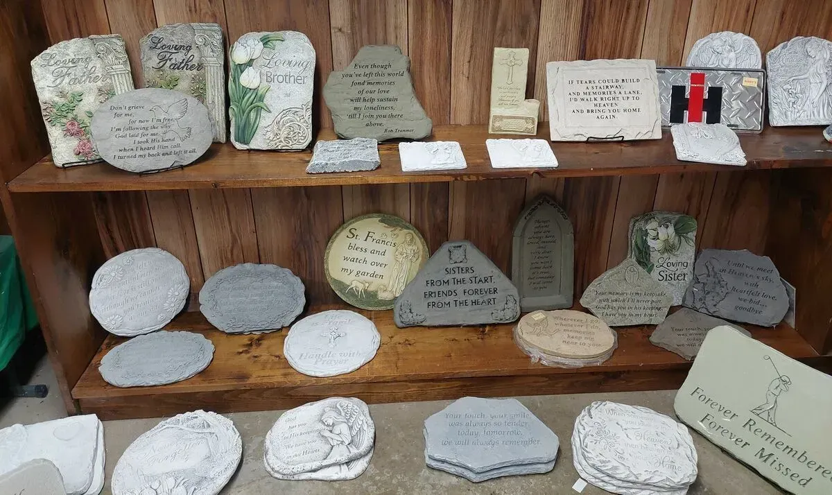Shelves holding decorative stone plaques with inscribed messages and designs.