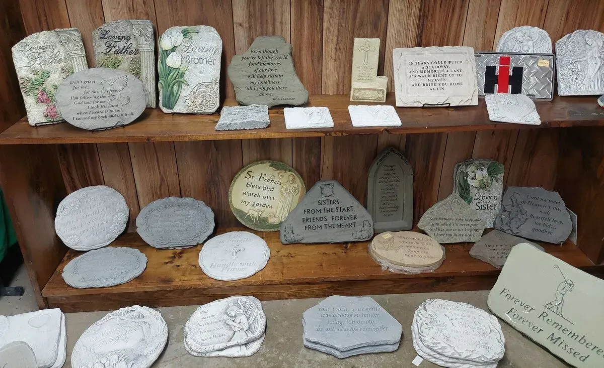 Shelves with various engraved stone plaques in a wooden display.