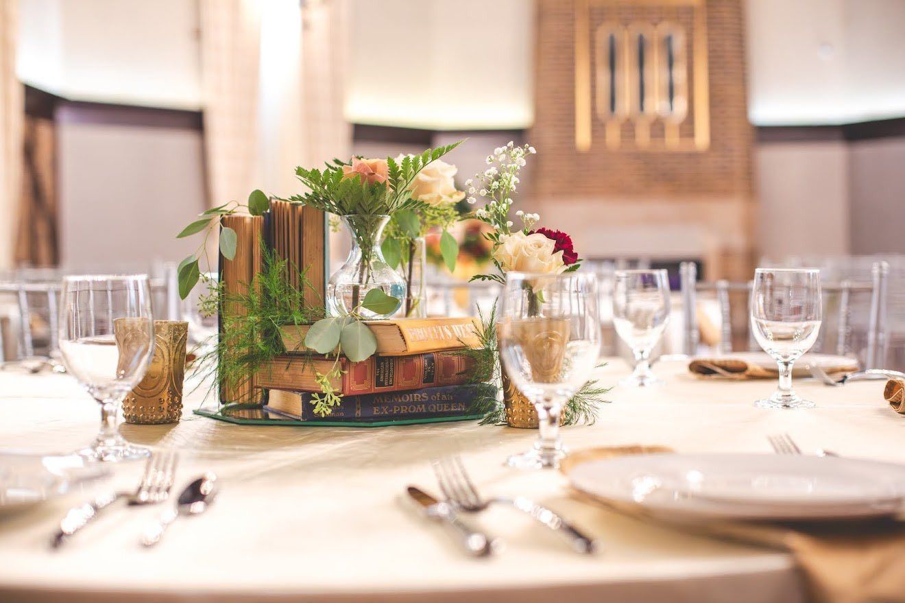 Wedding table setting with white tablecloth, floral centerpiece, and glassware, outdoors with sunlight. Wedding table setting with white tablecloth, floral centerpiece, and glassware, outdoors with sunlight.