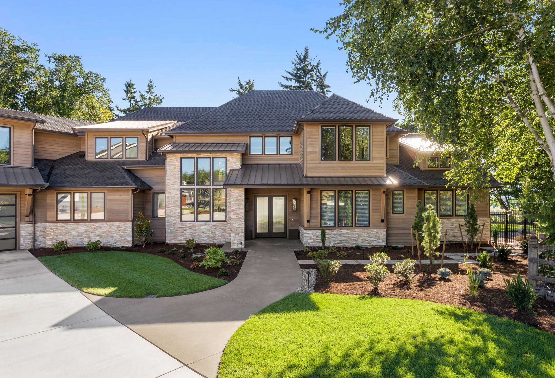 Two-story home with brown siding, stone accents, and dark roof.