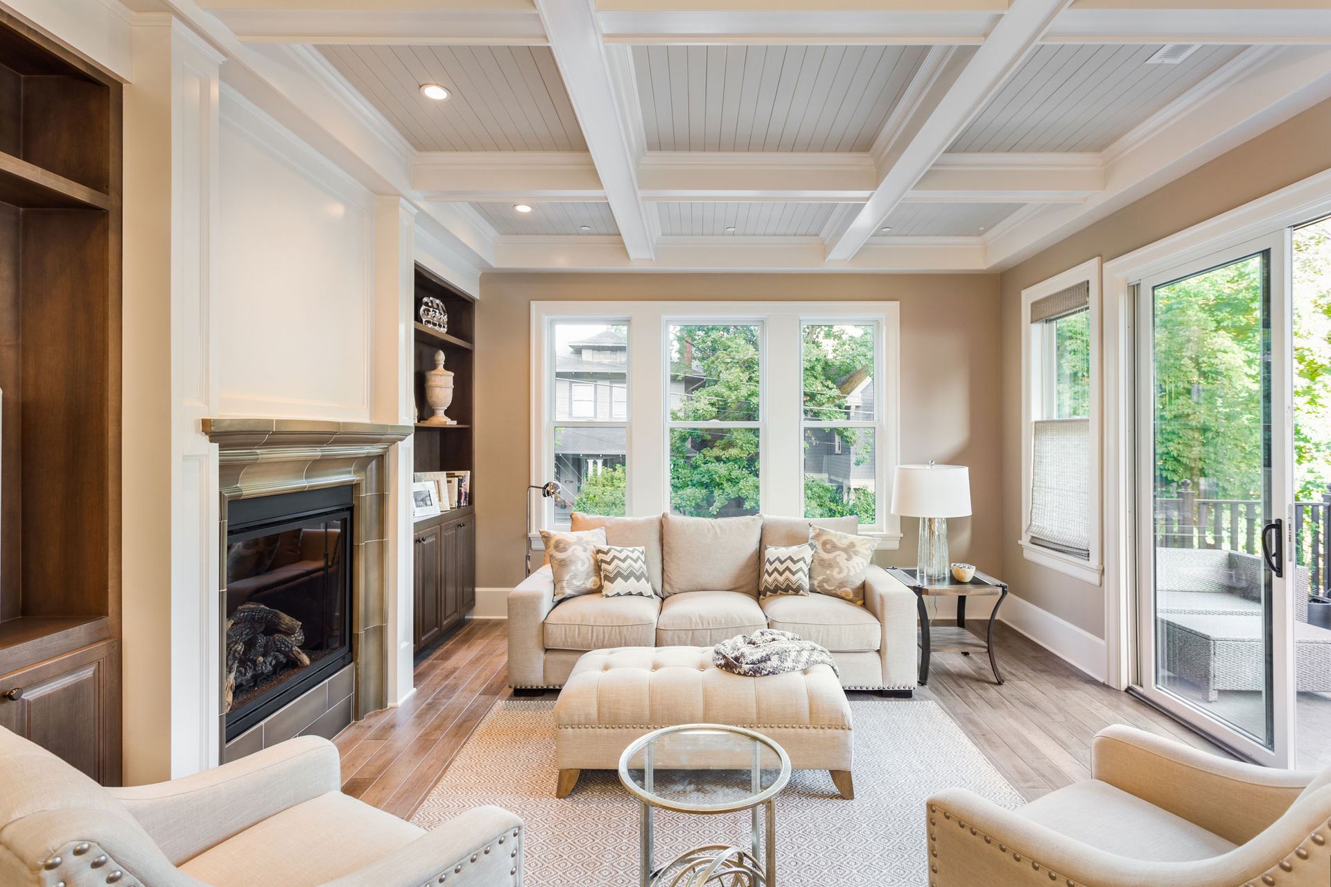 Living room with neutral tones, fireplace, built-in shelving, and large windows.