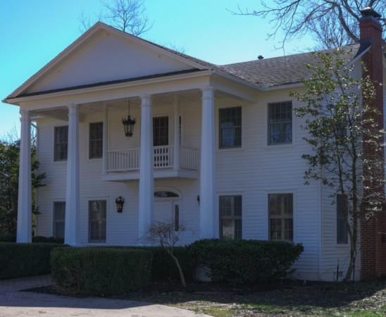 A large gray house with a black roof and white trim