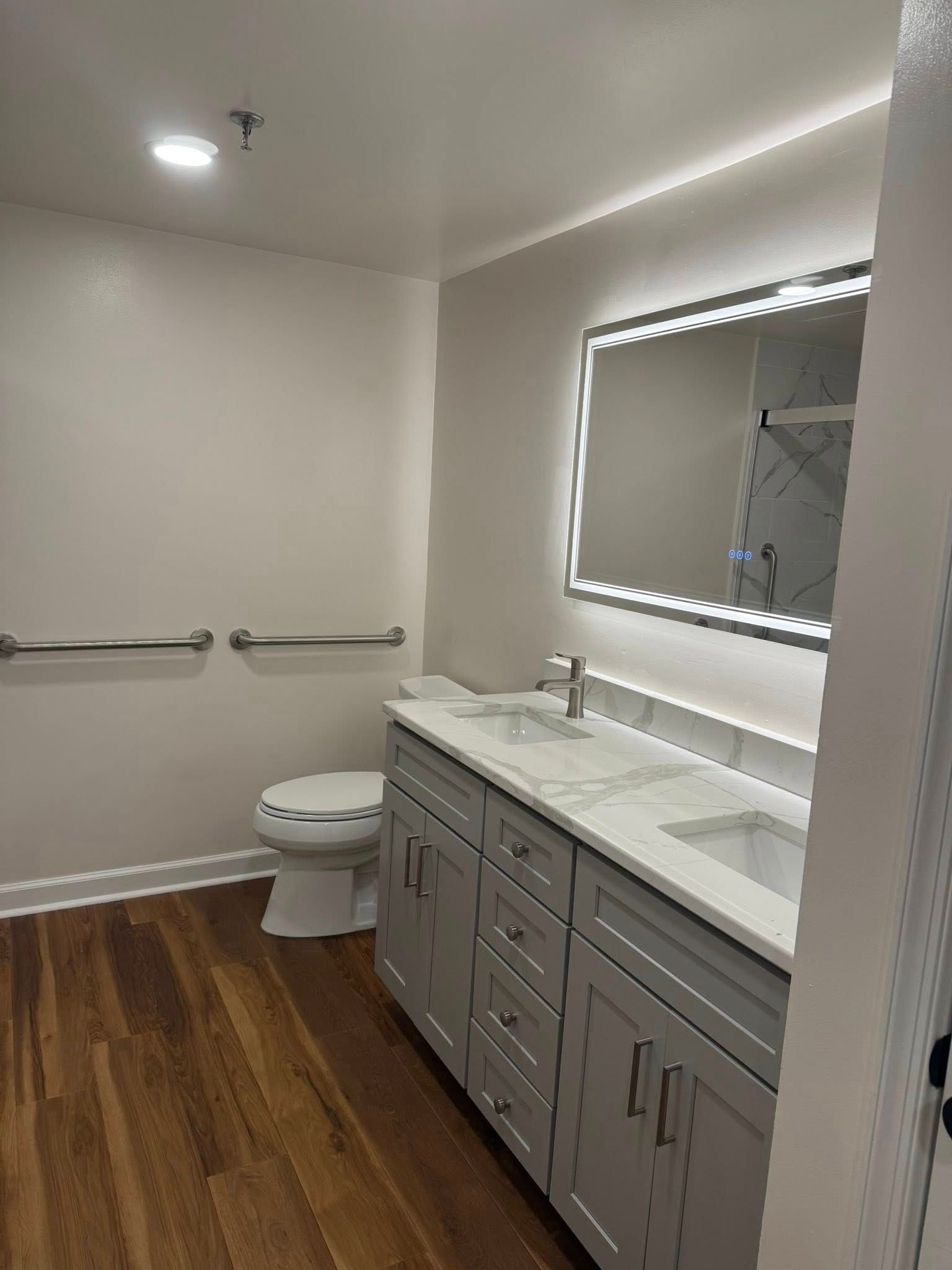Woman in straw hat smiles, holding wine glass near a lake.