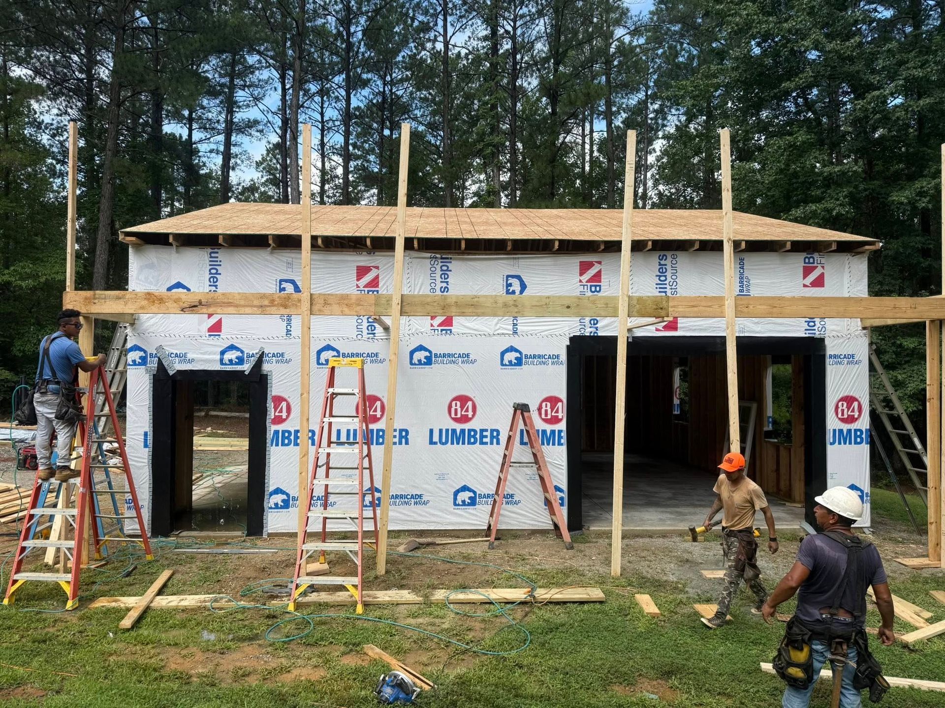 Woman in straw hat smiles, holding wine glass near a lake.