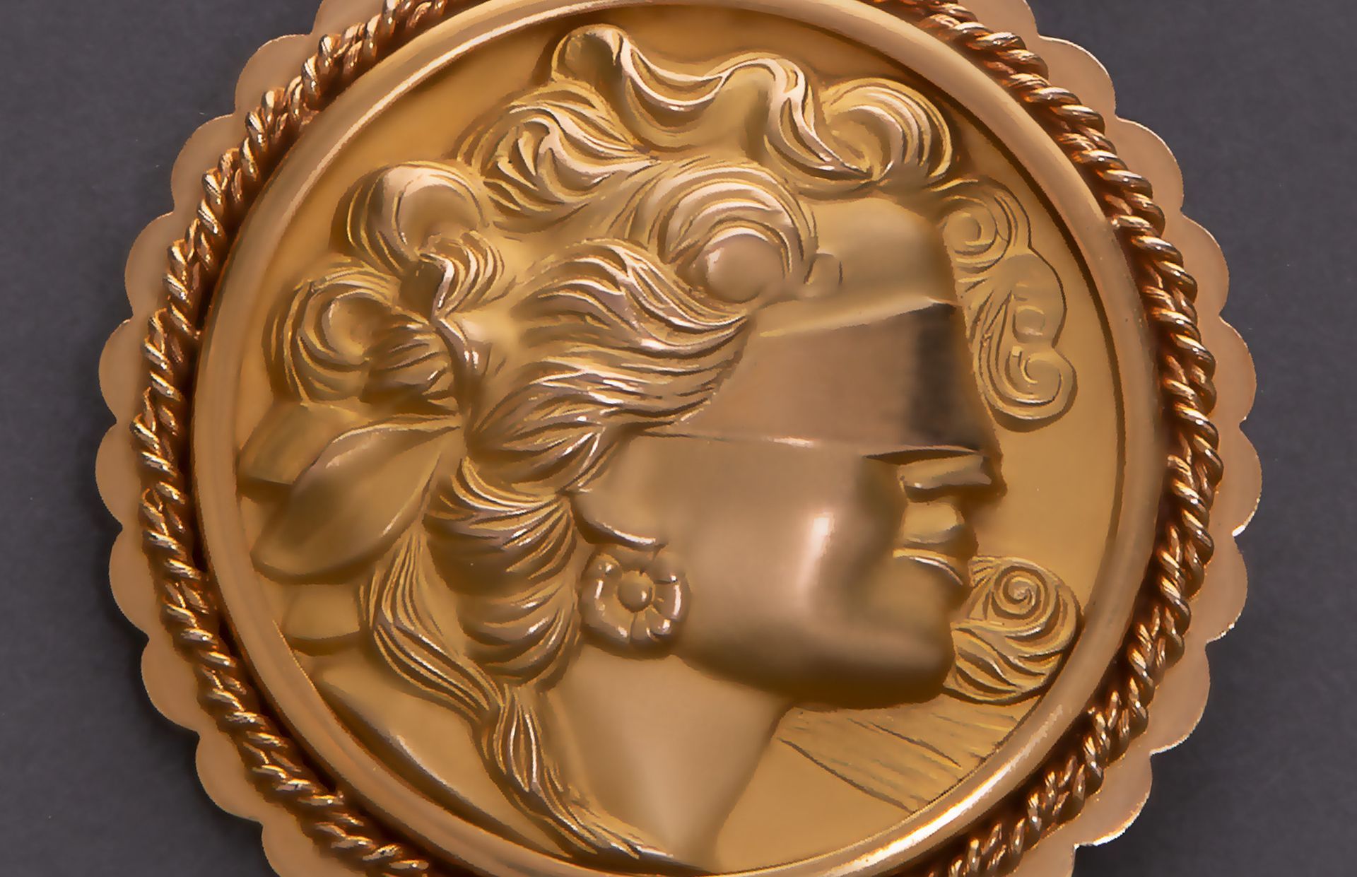 A gold coin with a woman 's face on it