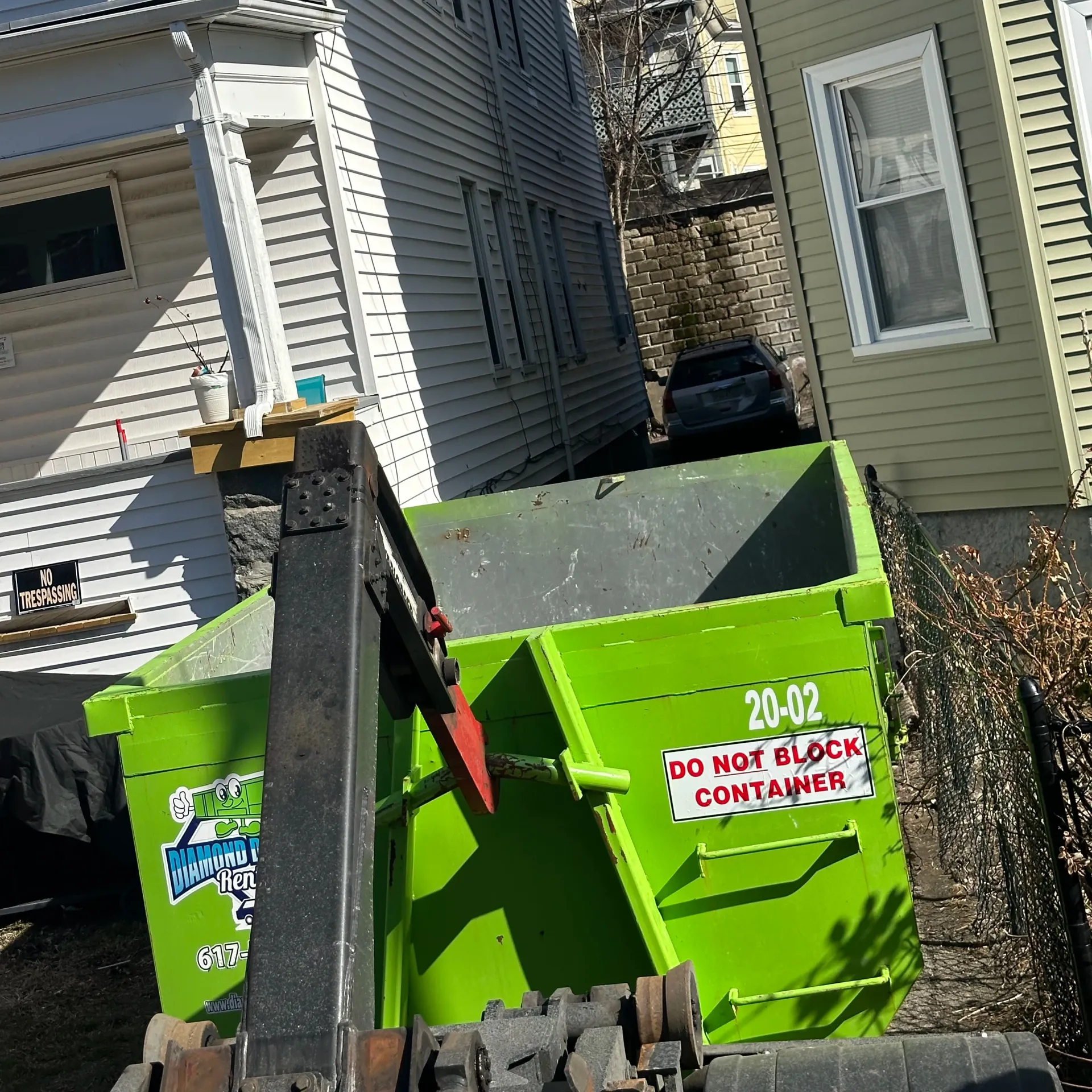 A green dumpster with the number 20-02 on it
