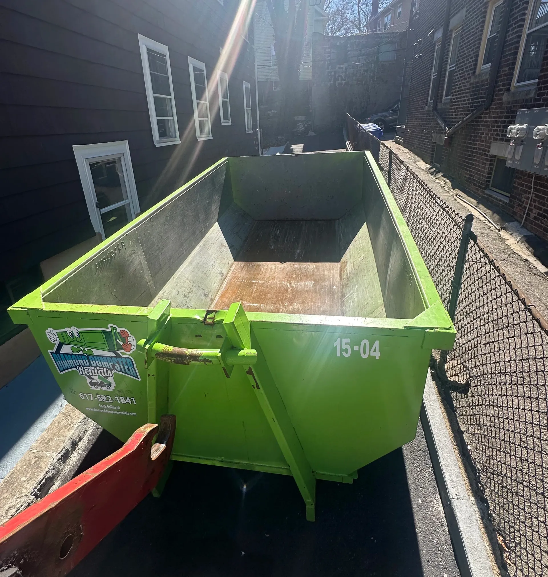 A green dumpster with the number 15-04 on it