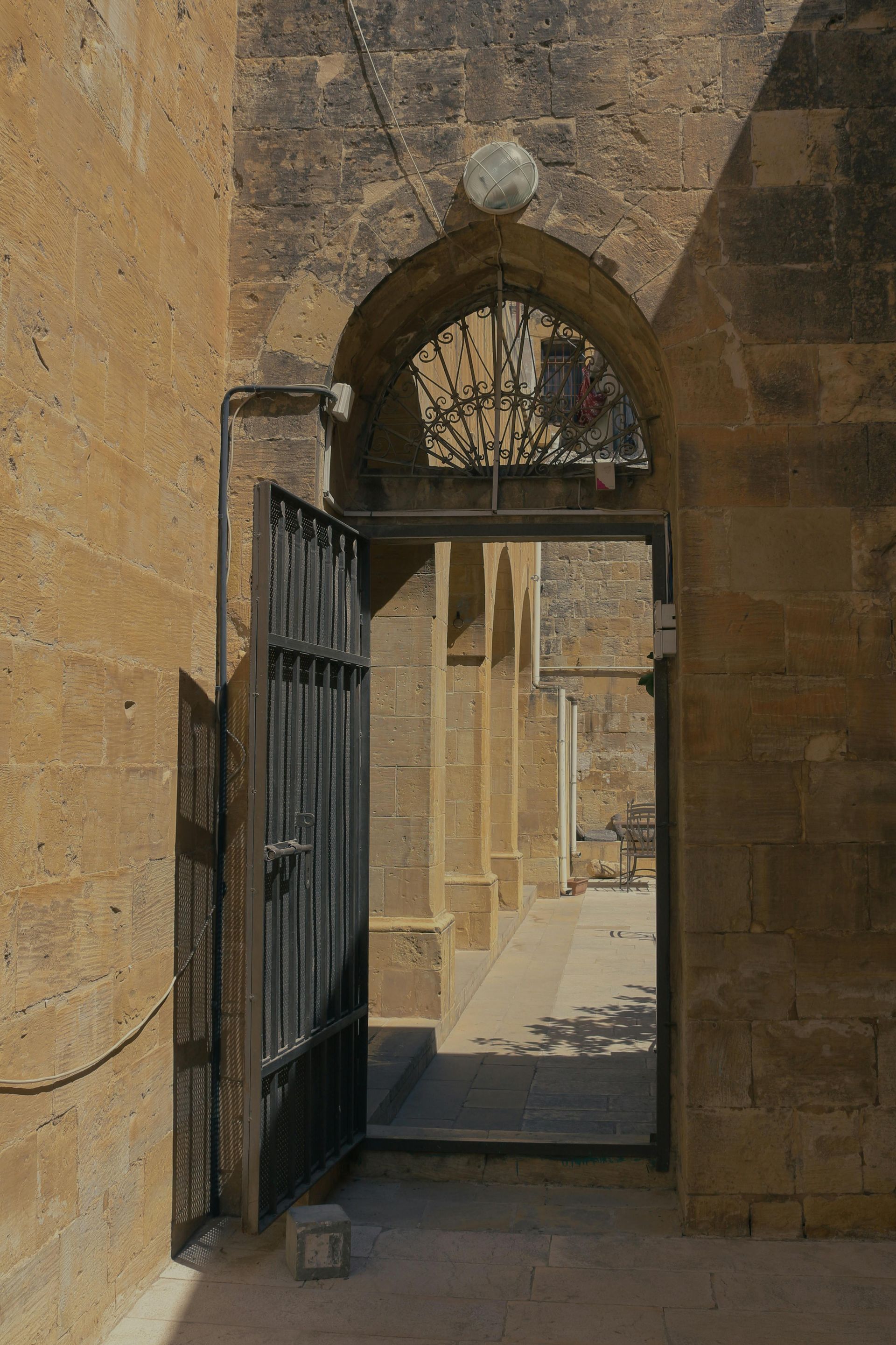 A stone building with a gate that is open