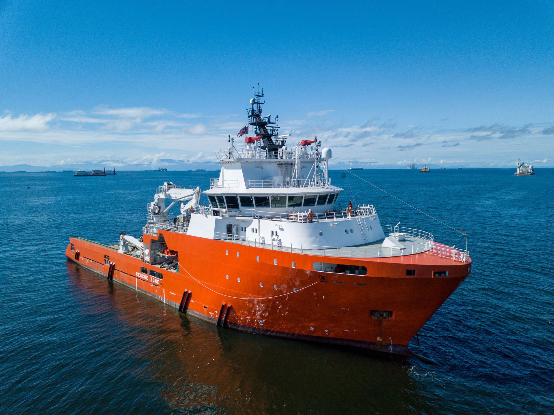 A white lighthouse in a blue shield on a blue background.