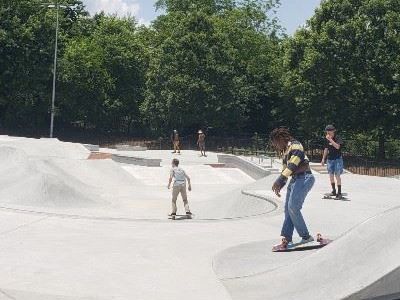 A man is riding a skateboard down a ramp at a skate park.