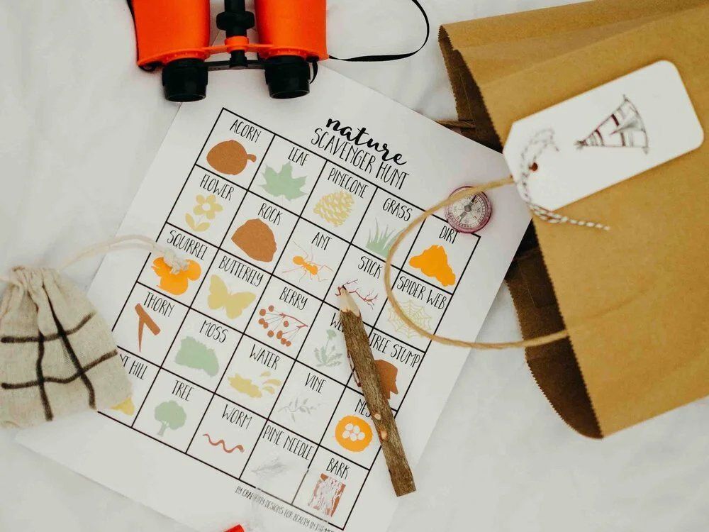 A bingo game is sitting on a table next to binoculars and a bag.