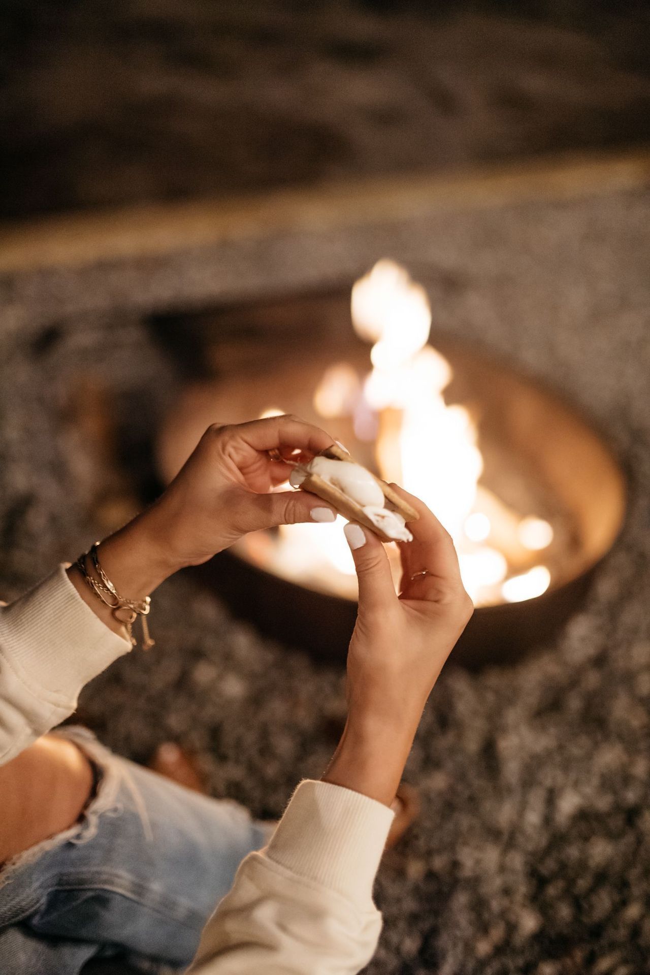 A person is roasting marshmallows over a fire pit.
