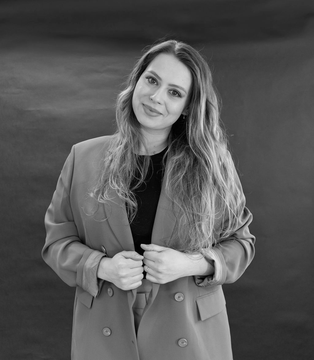 A black and white photo of a woman wearing a blazer.
