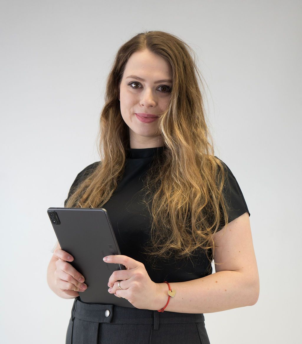 A woman in a black shirt is holding a tablet
