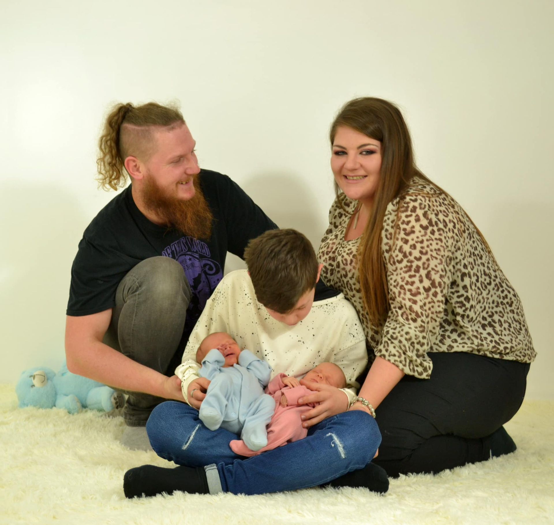A family posing for a picture with two babies