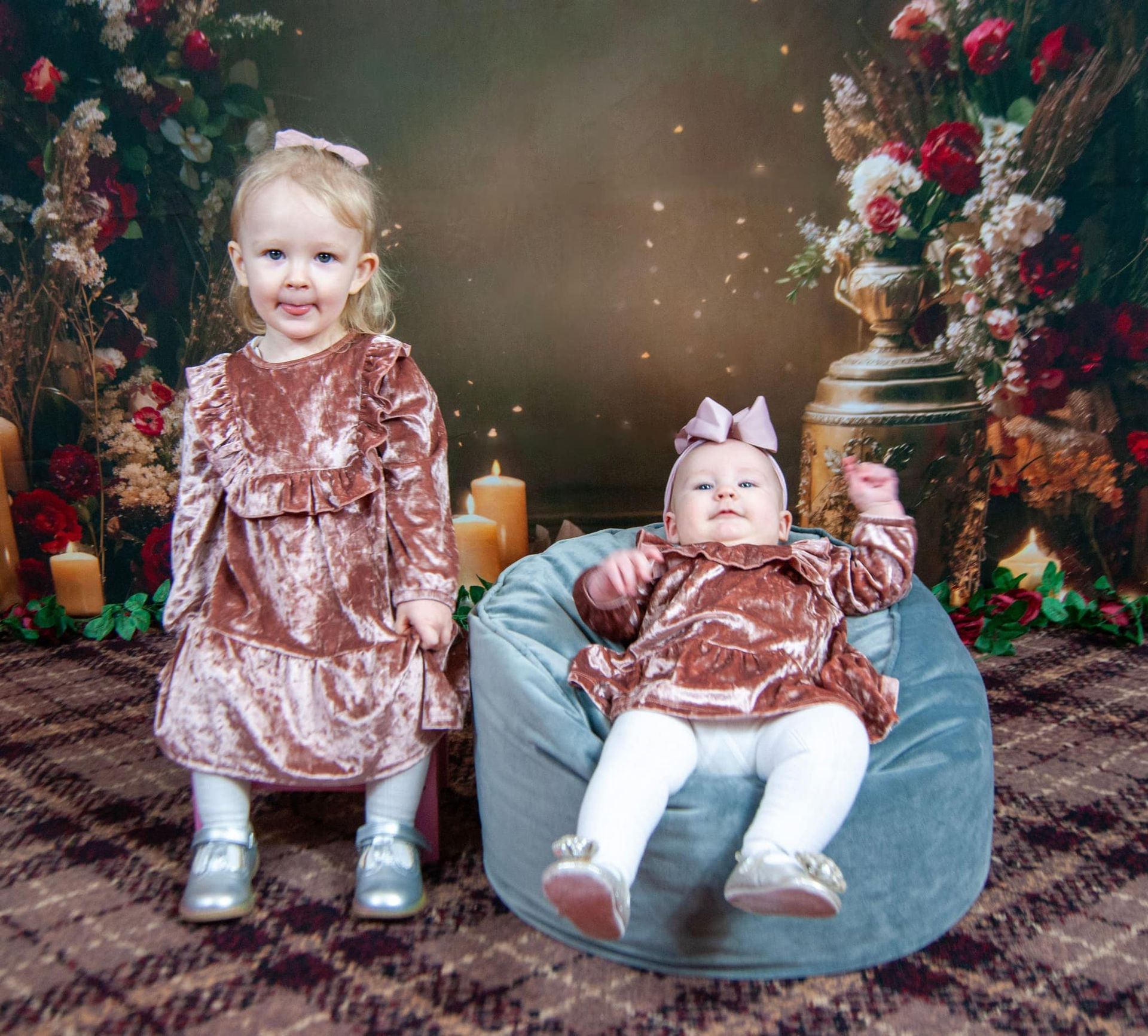 Two little girls are posing for a picture with candles in the background