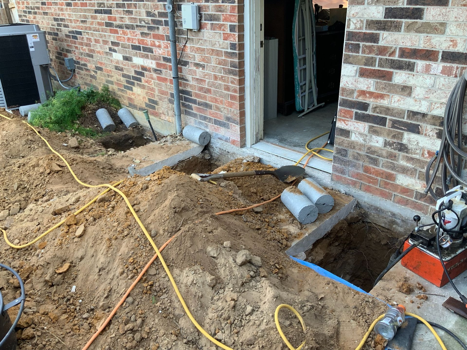 a shovel is in the dirt in front of a brick building