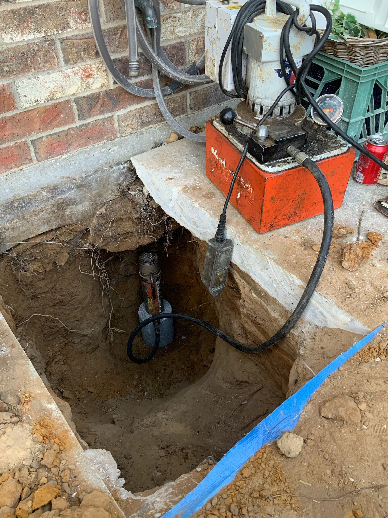 a hydraulic pump is sitting in the dirt next to a can of pepsi