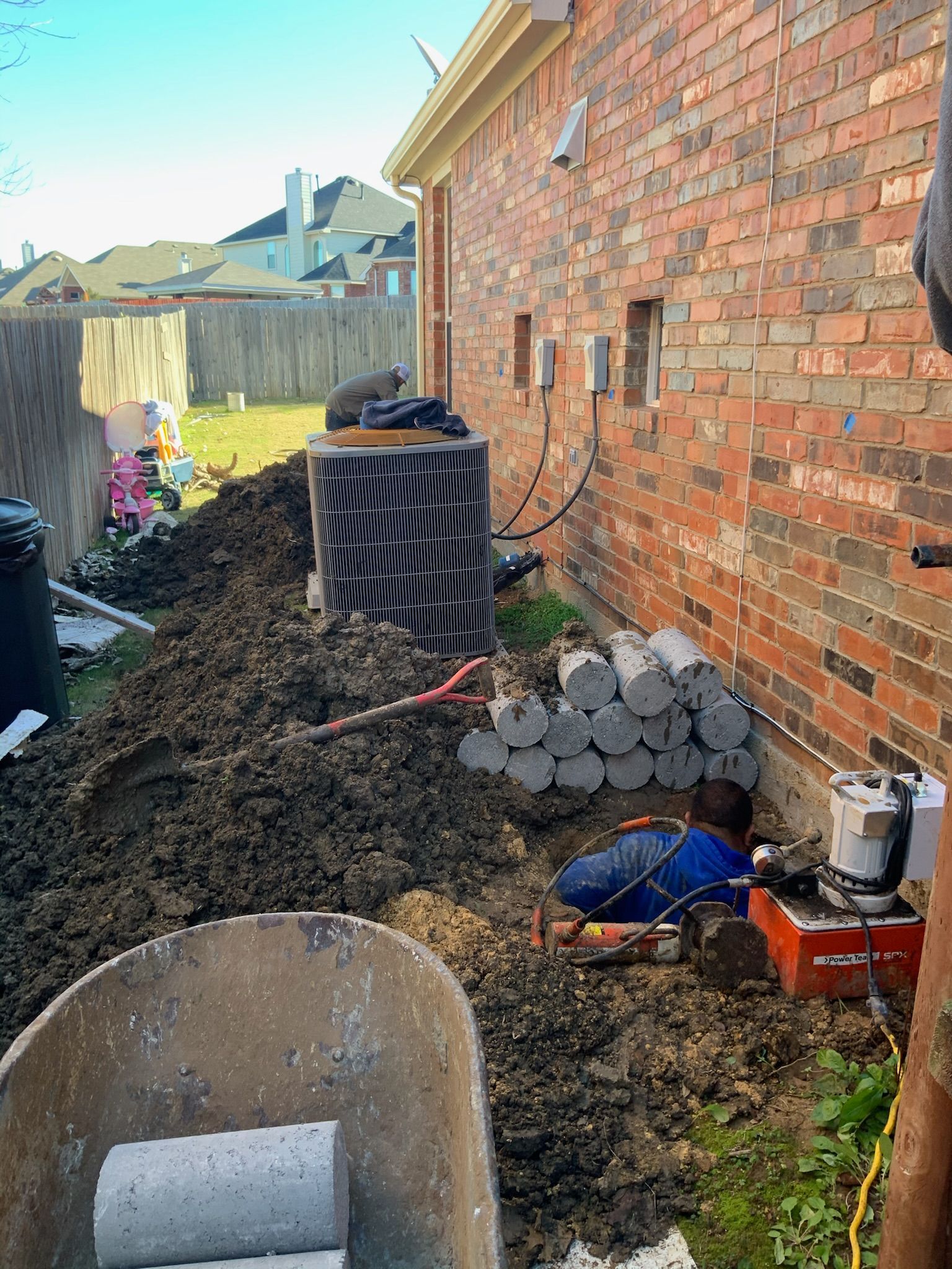 a man laying in the dirt next to a wheelbarrow