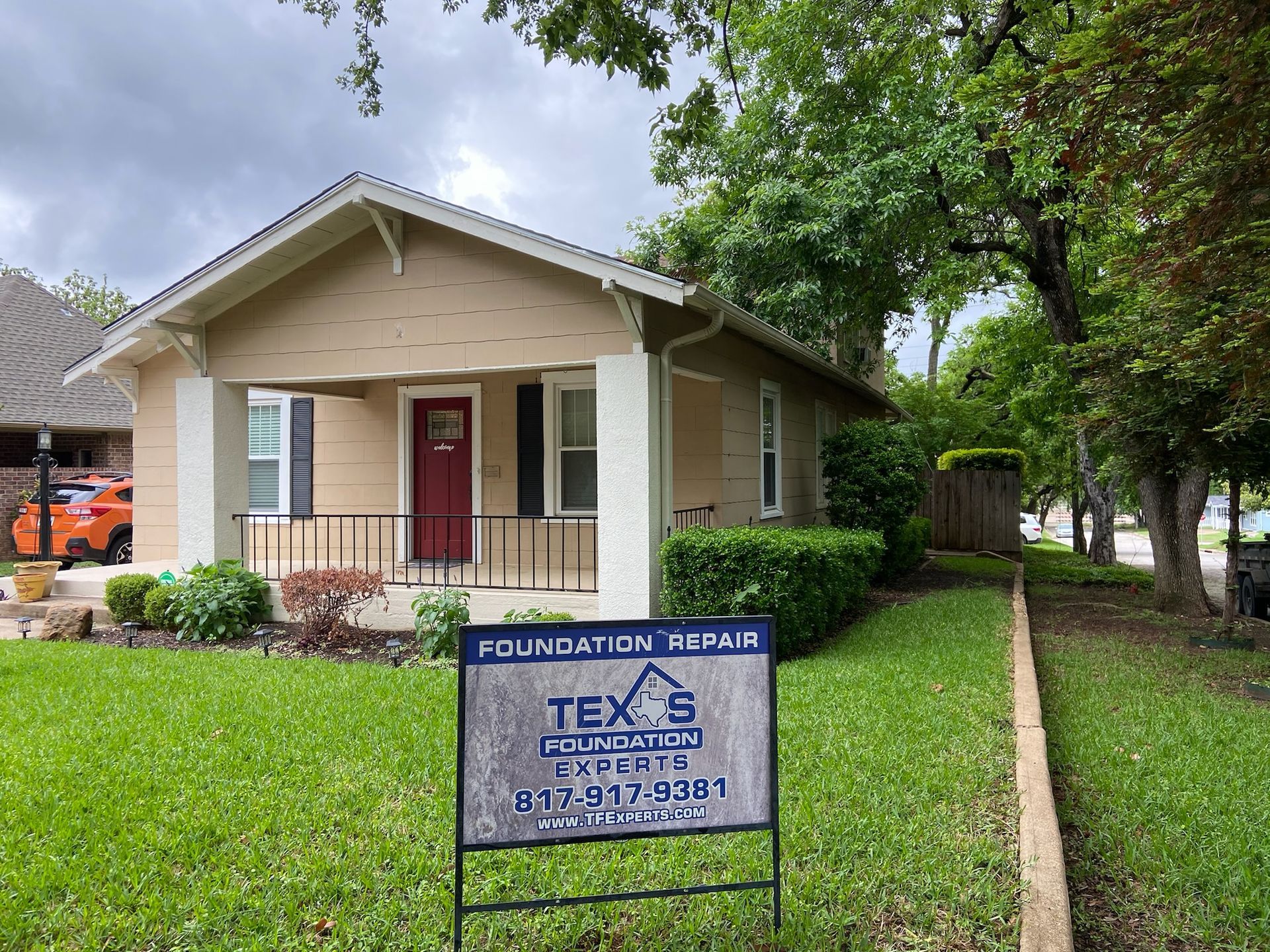 a house with a foundation repair sign in front of it