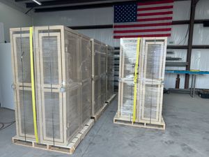 Two crates are stacked on top of each other in a warehouse with an american flag in the background.