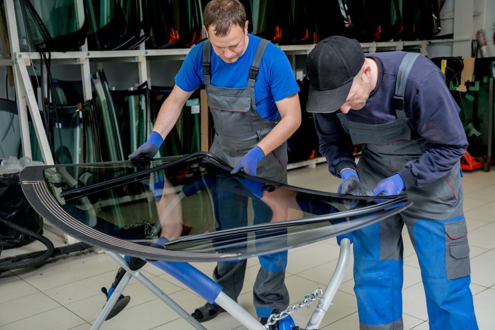 Two Auto Glass Technicians Inspecting a New Windshield in a Shop — Road Runner Windscreens in South Grafton, NSW