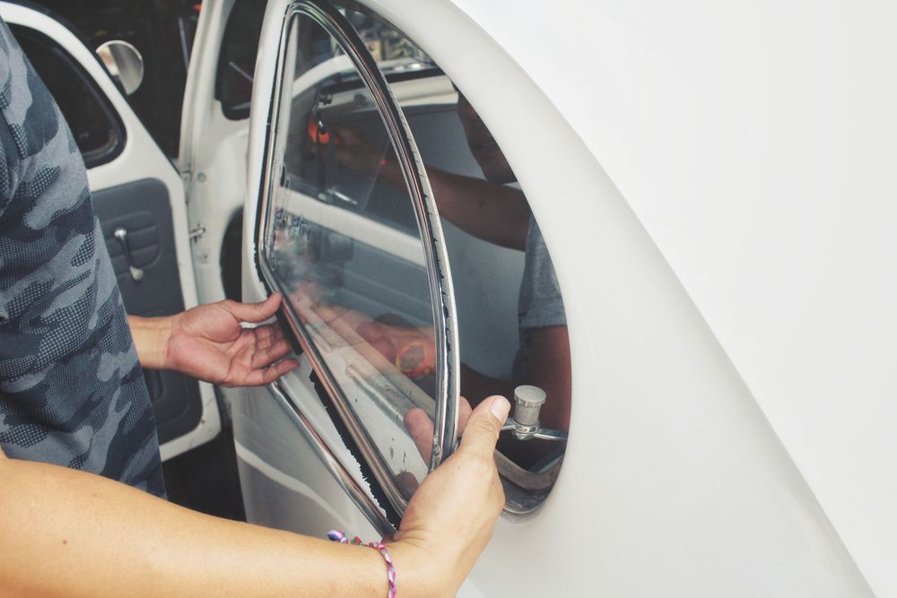 Person Installing a Curved Window in a Classic White Car — Road Runner Windscreens in South Grafton, NSW